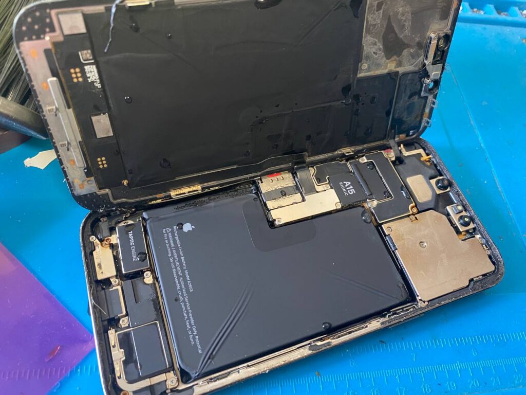 Phone exposed to water and steam on a blue repair mat.